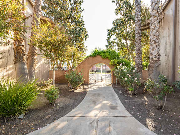 A garden pathway leads to a brick archway.