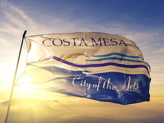 A man and a woman are walking on the beach. at Hamilton Courtyard Apartments, Costa Mesa, CA, 92627