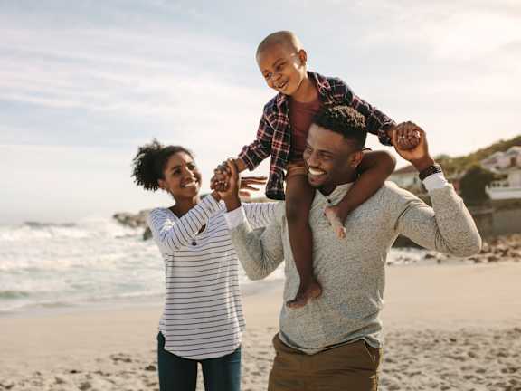 A man and a woman are walking on the beach.at Tamarack Sands Apartment Homes, Carlsbad, CA
