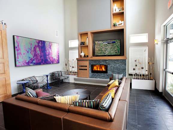 A living room with a brown couch and a TV on a stand.