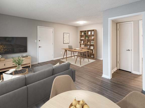 A living room with a grey couch, a wooden table, and a painting on the wall.
