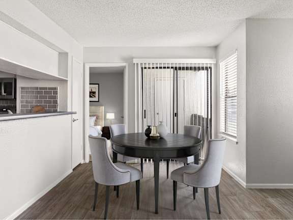A modern dining room with a black table and white chairs.
