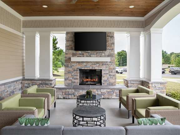 A patio with a fireplace and chairs.