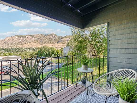 A balcony with a chair and a table with a plant on it at Cliffs at Canyon Ridge, Ogden, UT