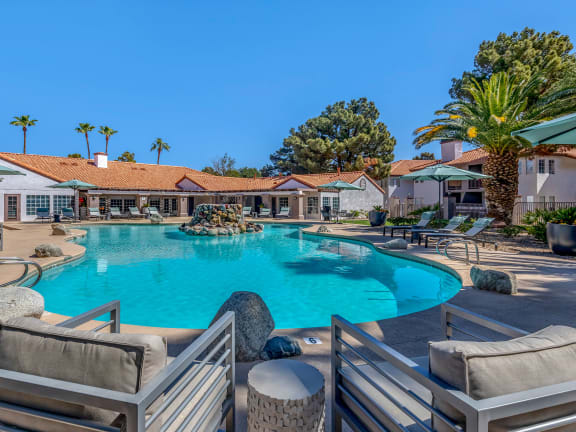 a large swimming pool with chairs and umbrellas at the resort