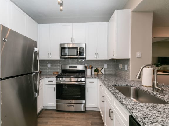 a kitchen with granite counter tops and stainless steel appliances at Willowest in Collier Hills in Atlanta, Georgia