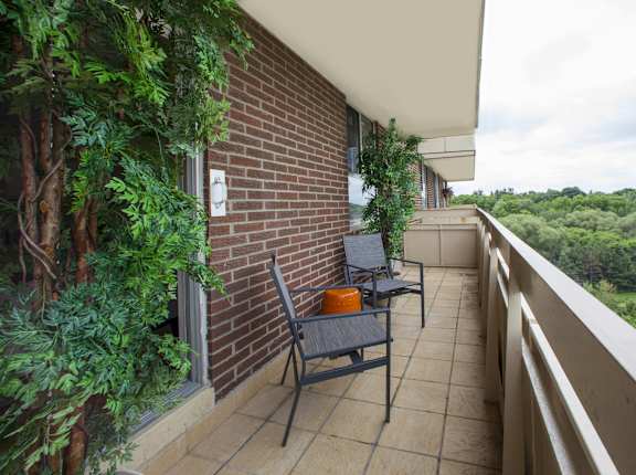 a balcony with a table and chairs and a brick wall