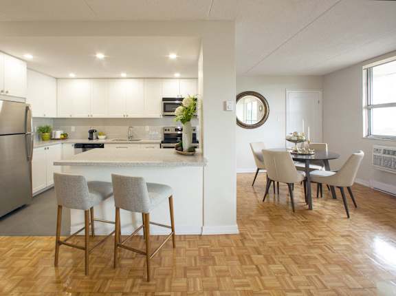 a kitchen and dining room with a table and chairs and a refrigerator