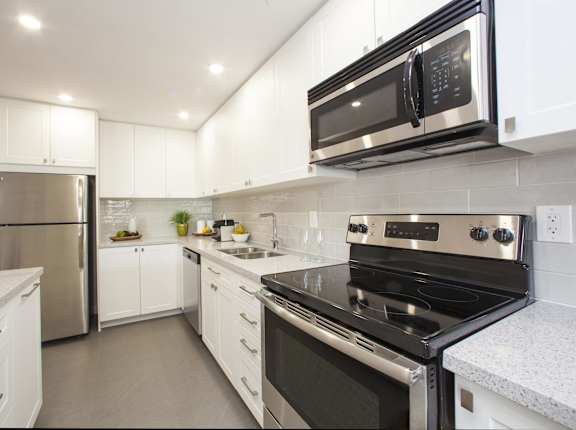 a kitchen with stainless steel appliances and white cabinets