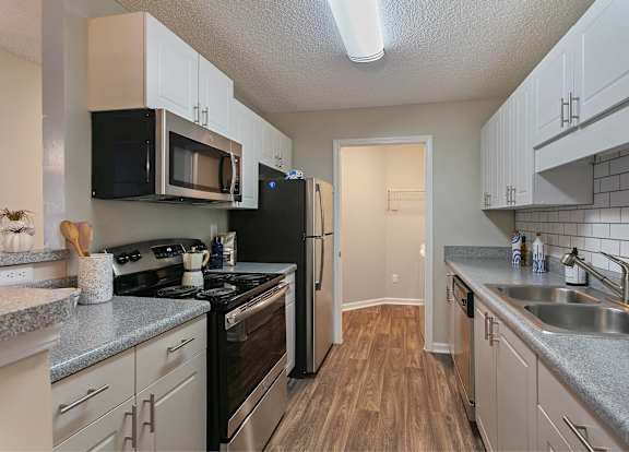 A kitchen with black appliances and white cabinets.