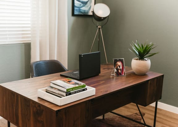 Desk with a laptop and a stack of books on it at South Pine, Union City, GA, 30291