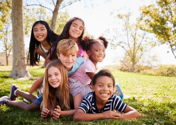 a group of kids laying in the grass