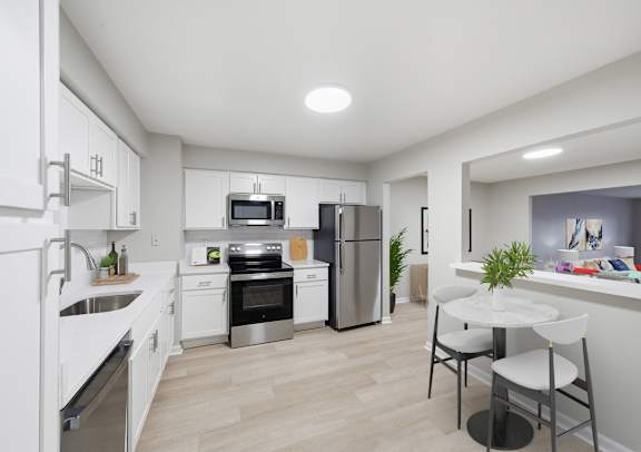 A modern kitchen with white cabinets and stainless steel appliances.