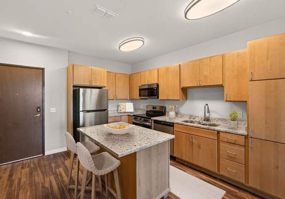 A kitchen with wooden cabinets and a granite countertop.
