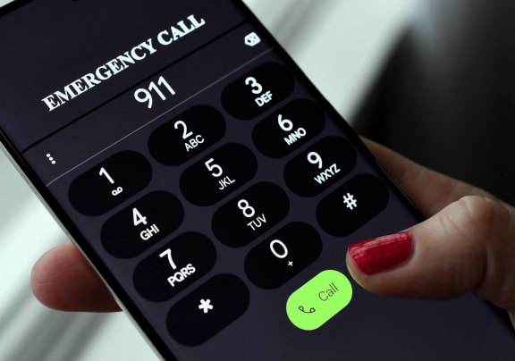 a hand holding a phone with an emergency call button on the screen