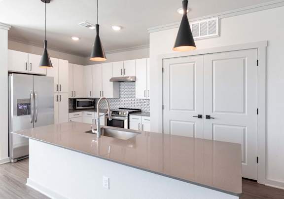 A kitchen with a white counter and cabinets.