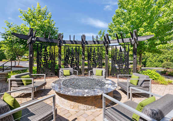 A patio with a fire pit and seating area.