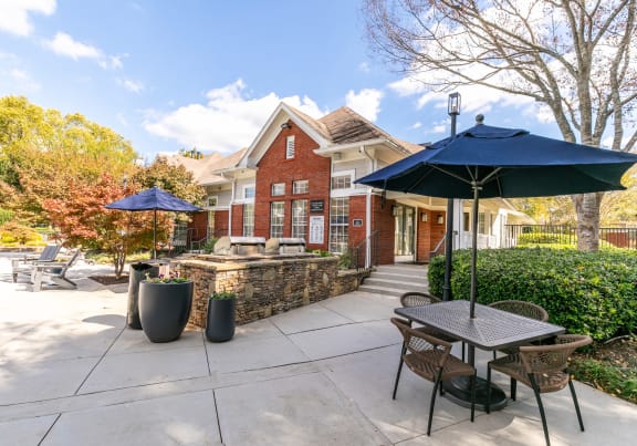 a patio with tables and umbrellas in front of a house at Roswell Village in Roswell, Georgia