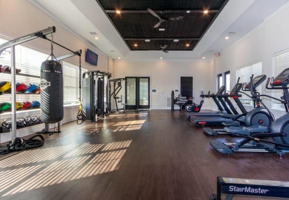 a gym with weights and a punching bag on the wall