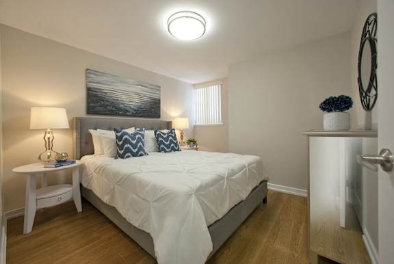 a bedroom with a white bed and a painting on the wall