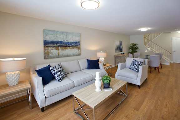 a living room with a couch and two chairs and a table