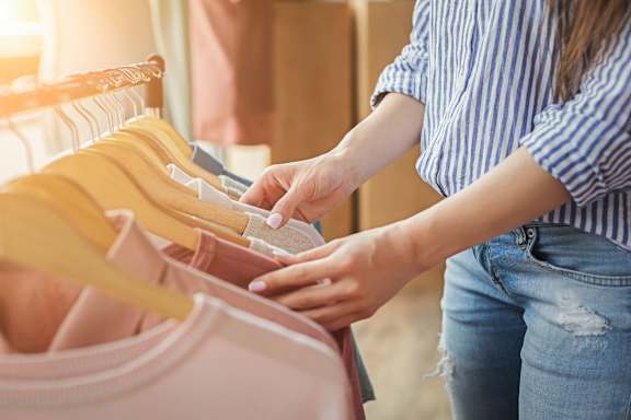 a woman picking out purses in a closet