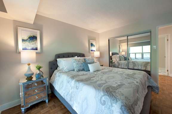 a bedroom with a large bed and a mirror