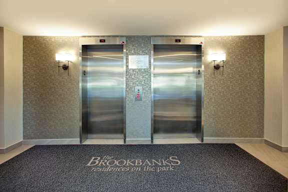 two stainless steel elevators in the lobby of a building