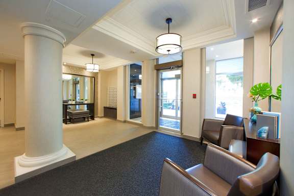the lobby of a dental office with chairs and a table