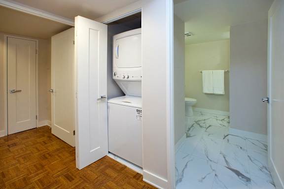 a small bathroom with a washer and dryer in a closet