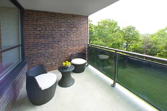a balcony with two chairs and a table and a window