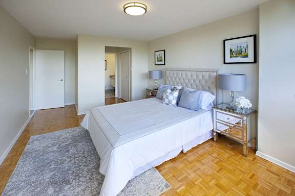 a bedroom with a large white bed and a wooden floor