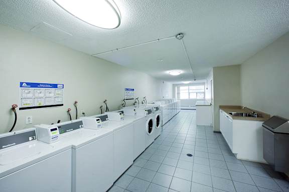 a laundry room with washers and dryers and a sink