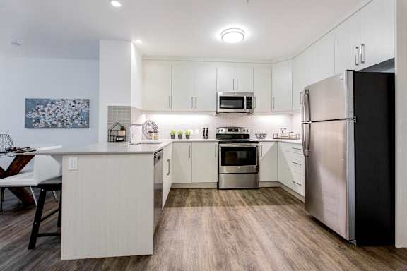a kitchen with white cabinets and stainless steel appliances