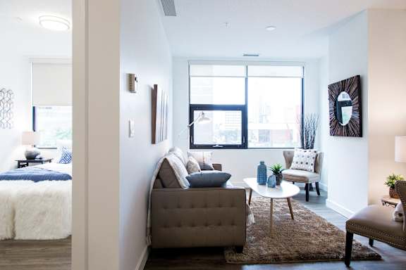 a living room with a couch and chairs and a window