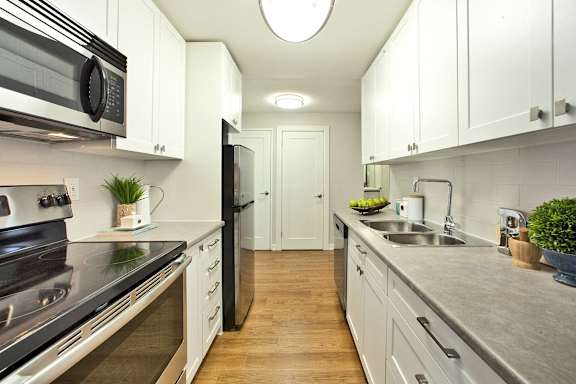 a kitchen with white cabinets and stainless steel appliances and a sink