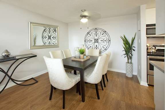 a dining room with white chairs and a black table
