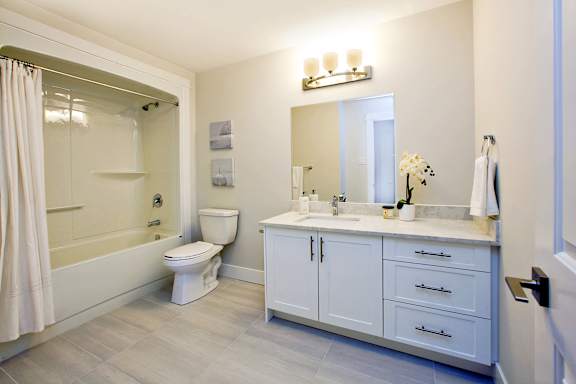 A white bathroom with a toilet, sink, and bathtub.