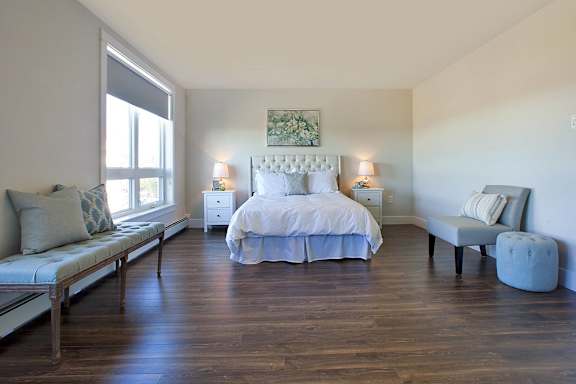 A bedroom with a large bed and a bench.