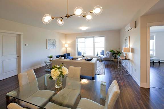 A modern living room with a glass table and chairs.