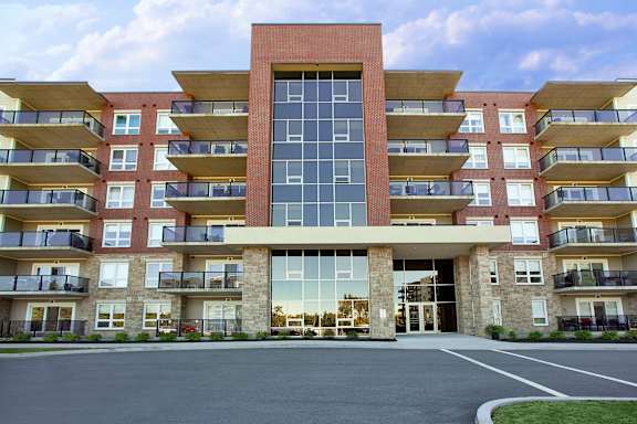 A large apartment building with a central entrance and balconies on each floor.