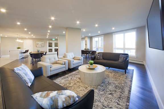 A living room with a black leather couch and a coffee table.