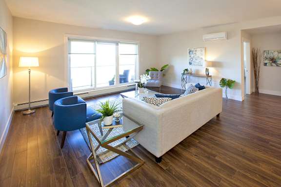 A living room with a blue chair and a white couch.
