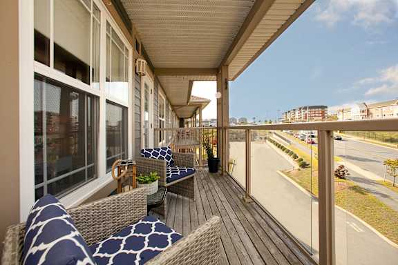A balcony with a table and chairs overlooking a street.