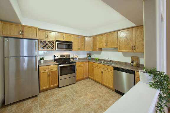 A kitchen with wooden cabinets and a tiled floor.