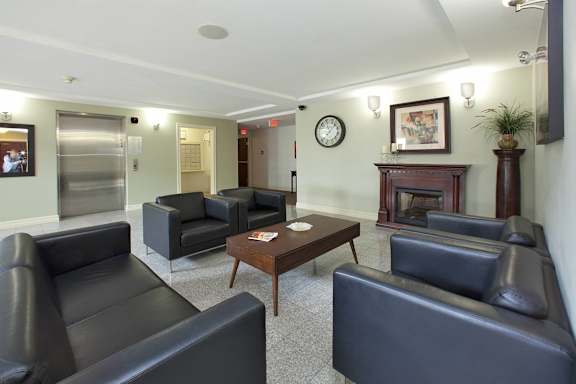 A living room with a fireplace and a clock on the wall.