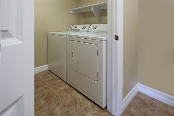 A white dryer and washer in a small laundry room.