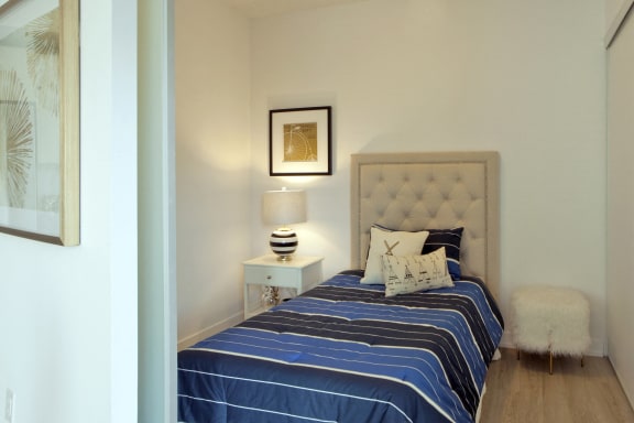 a bedroom with a bed and a night stand with a lamp