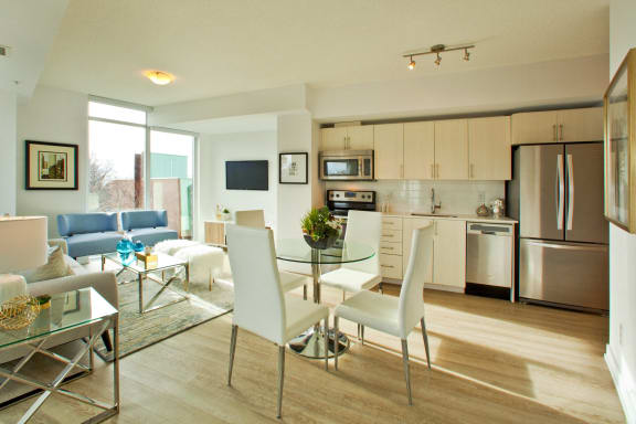 a living room and dining room with a table and chairs