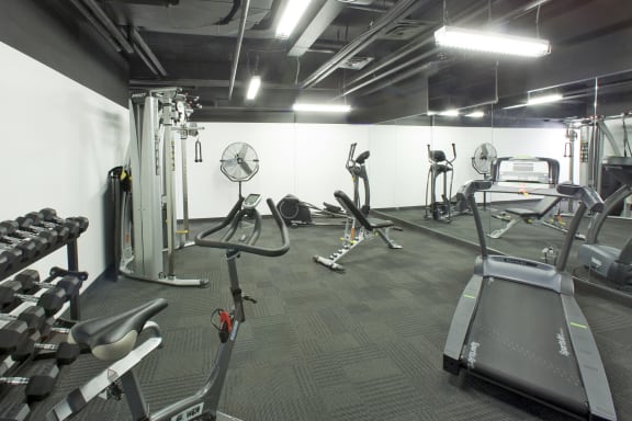 a gym with various exercise equipment in a building with white walls